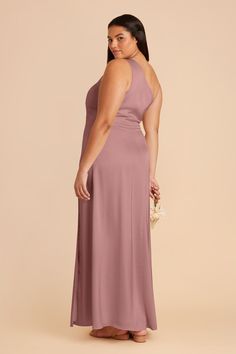 a woman in a long purple dress with her back to the camera, looking down