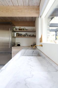 a kitchen with marble counter tops and stainless steel appliances in the background, on instagram