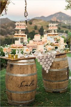 the wedding cake is sitting on top of two wine barrels, and it's decorated with flowers