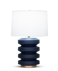 a blue lamp with a white shade on the top and bottom, against a white background