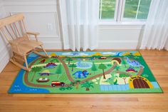 a child's room with a rocking chair and play mat on the floor in front of a window