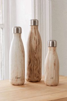 three wooden bottles sitting on top of a table