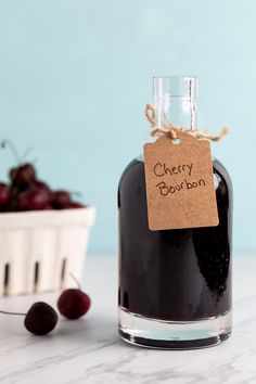 a bottle of cherry bourbon next to a bowl of cherries