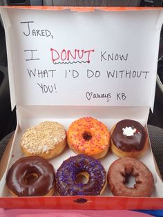 six donuts are in a box with writing on the front and back side,