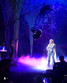 a woman standing on top of a stage holding a microphone