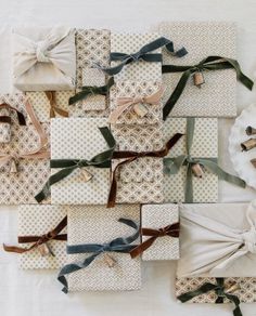 many wrapped presents are arranged on top of each other with ribbons and bows around them