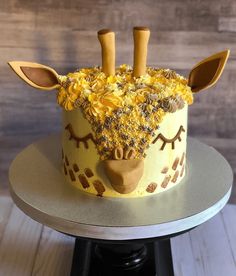 a giraffe cake is decorated with yellow flowers