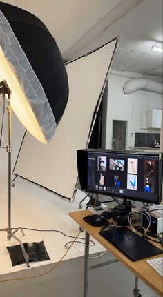 a photo studio setup up with lighting and camera equipment on a table in front of a monitor