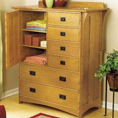 a wooden dresser with drawers and an apple sitting on it's top shelf next to a potted plant