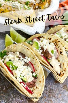 steak street tacos on a plate with lime wedges and other mexican food in the background