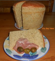 two slices of bread sitting on top of a plate with olives next to it