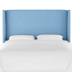 a blue headboard with white sheets and pillows