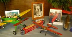 an assortment of toy airplanes and pictures on a table