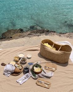 a picnic on the beach is set up with food and utensils for two