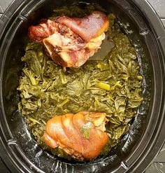 two pieces of meat and greens in a slow cooker