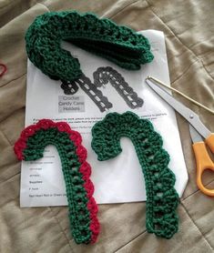 crocheted christmas stockings and scissors on top of a piece of paper