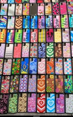 many different colored cell phones are arranged in the shape of squares and hearts on display