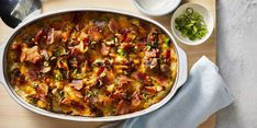 a casserole dish with meat and vegetables on a cutting board next to other dishes