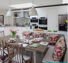 a kitchen with a table, chairs and couches in the middle of the room