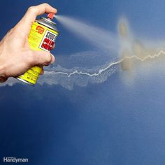 a person spraying paint on the side of a car