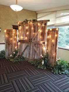 an open barn door decorated with lights and greenery