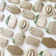 wedding cookies are arranged on a table with names and date tags for guests to choose from