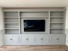 an entertainment center with built - in cabinets and a flat screen tv on the wall