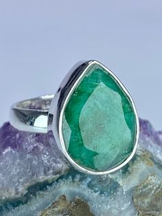 A beautifully sophisticated deep Green faceted raw Emerald and sterling silver ring. The stone is a good size, of a beautifully refreshing and eye-catching emerald green, pear-cut and set in classic bezel. Weight - 5 grams Stone size  - 1.8cm long x 1.4cm wide (widest point) and 0.7cm deep. This ring is made utilising hypoallergenic pure 925 silver and is nickel, cadmium and lead free. About the stone: Emerald is known as the "stone of successful love".  It brings loyalty and provides for domest