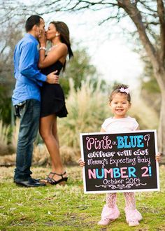 a man and woman kissing while holding a sign