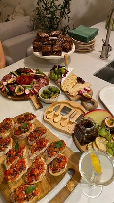 a table full of food including pizzas, salads and appetizers on wooden cutting boards