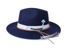 "The Carlos hat from the Oaxaca Collection  Type: Center Dent Wide Brim Fedora Specifications: Adjustable Size- With a tie of a knot, adjust the fit of your hat to the ideal size from 21 ¼ to 23 ¼ inches. Dimensions: Wired Brim: 2 7/8\", Crown: 4\" Color: Navy Blue Materials:  65% Cotton , 35% Polyester  Tan Leather Cord  Oaxacan Custom Hat band Antique Beads Suede Cord Origin: All of our hats begin in Ecuador as the body is molded, then completed at our studio in Tucson, AZ. Here we shape, trim Adjustable Navy Wide Brim Hat, Blue Fedora Hat, Womens Fedora, Wide Brim Fedora, Unique Hats, Hat Ideas, Suede Cord, Tucson Az, Felt Hat