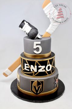 a three tiered cake with an ice hockey themed design and the number five on it