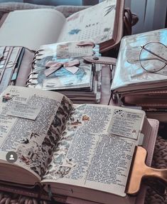 an open book sitting on top of a table next to glasses and other items in a suitcase