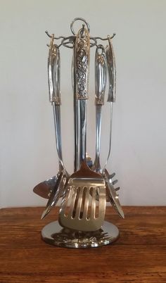 a silver vase with four knives on top of it