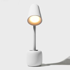 a white table lamp sitting on top of a white floor next to a shadowless wall