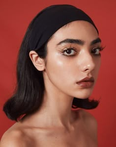 a woman with dark hair wearing a black headband