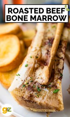 roasted beef bone marrow on a white plate with french fries and garlic bread