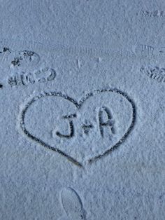 two hearts drawn in the snow with initials