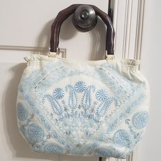 Small Fabric Handbag In Ivory With Lightweight, Dark Wooden Handles. Handbag Is Overlaid With Delicately Embroidered Sheer Fabric. Embroidery Floss Is A Lovely Blue Pastel And Silver. - Nwot - Pet- And Smoke-Free Home - Handbag (Excluding Handles) Measures 22" Wide X 10" Long Blue Bags With Floral Embroidery For Spring, Blue Embroidered Shoulder Bag For Shopping, White Embroidered Shopping Bags, Embroidered White Shoulder Bag For Vacation, White Embroidered Shoulder Bag For Vacation, Embroidered Cream Shoulder Bag, White Embroidered Beach Bag, Cream Embroidered Tote Bag, Embroidered Cream Shoulder Bag For Summer