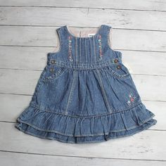 New With Tags Oshkosh B'gosh Vintage Denim Blue Jean Jumper Dress With Floral Detail Sleeveless Button Fasteners Pintuck Bodice Embroidered Flowers Layered Ruffle Hem Pockets Main Colors: Blue Pink Purple Green Shell: 100% Cotton Striped Lining: 65% Polyester 35% Cotton Machine Wash Spring Summer Fall Winter Infant Baby Girl Size 9 Months This Dress Is Slightly Vintage In Age And Is Brand New With Tags. Playful Denim Dress For Spring, Sleeveless Denim Playtime Dress, Spring Pink Denim Dress, Sleeveless Pink Denim Dress, Playful Denim Dress For Playtime, Vintage Baby Girl Clothes, Vintage Oshkosh, Baby Denim Overalls, Vintage Baby Clothes 90s