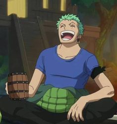 an anime character with green hair and blue shirt sitting on the ground, holding a barrel