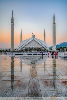 people are standing in front of a large building with two spires on each side