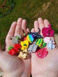 two hands holding small plastic animal figurines in the middle of their palms