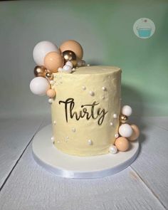 a birthday cake decorated with balloons and the word thirty on it's top tier