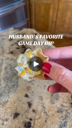 a hand holding a piece of food with the words husband's favorite game day dip