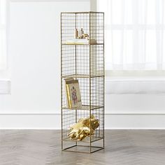 a gold metal shelf with pictures and photos on it in front of a white wall