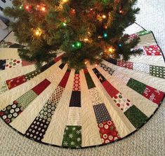 a christmas tree skirt with lights on it and a small tree in the center is shown