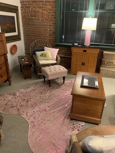 a living room filled with furniture and a pink rug on top of a carpeted floor