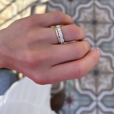 a woman's hand with a wedding ring on her left and a diamond in the middle