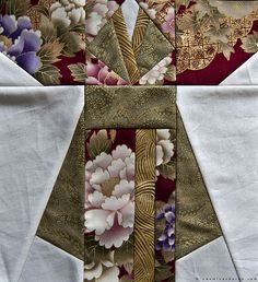 a close up view of a quilted piece of fabric with flowers and leaves on it